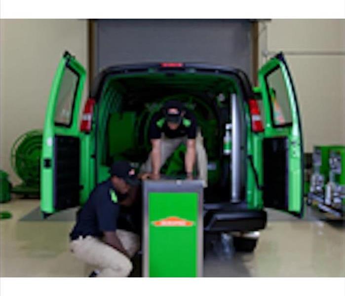 A SERVPRO professional loading equipment into the van.